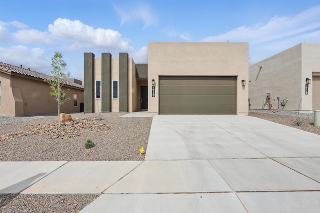 1718 Tesoro Loop NW, Los Lunas, NM 87031 - pueblo-style home with a garage, driveway, and stucco siding
