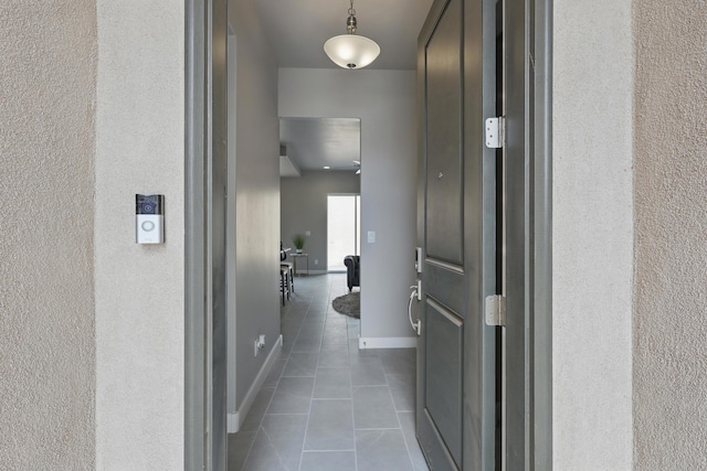 1718 Tesoro Loop NW, Los Lunas, NM 87031 - hall featuring dark tile patterned flooring, baseboards, and a textured wall