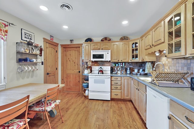 kitchen with decorative backsplash, visible vents, light brown cabinetry, light wood-type flooring, and white appliances