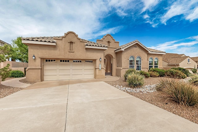 2413 Desert View Rd NE, Rio Rancho, NM 87144 - mediterranean / spanish-style home featuring stucco siding, concrete driveway, an attached garage, and a tiled roof