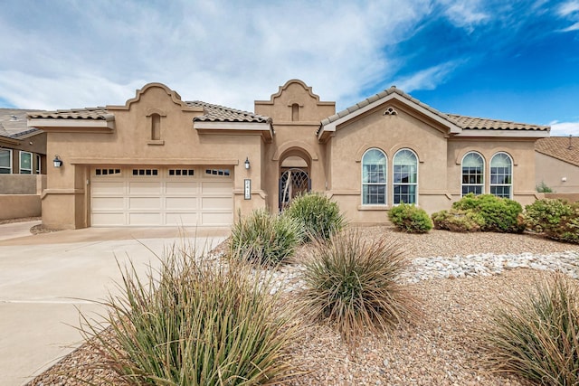 2413 Desert View Rd NE, Rio Rancho, NM 87144 - mediterranean / spanish home with stucco siding, a garage, concrete driveway, and a tiled roof