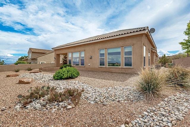 2413 Desert View Rd NE, Rio Rancho, NM 87144 - rear view of house with stucco siding, fence, and a tiled roof