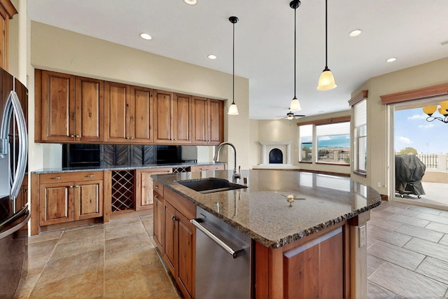2413 Desert View Rd NE, Rio Rancho, NM 87144 - kitchen with appliances with stainless steel finishes, a sink, brown cabinetry, dark stone countertops, and ceiling fan