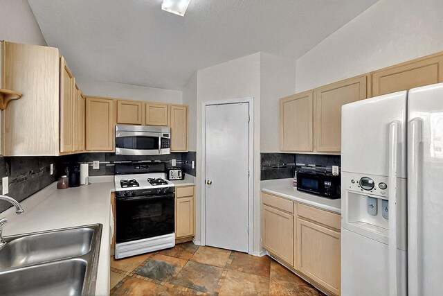 5401 Crown Ridge Rd NW, Albuquerque, NM 87114 - kitchen featuring stainless steel microwave, range with gas stovetop, white fridge with ice dispenser, light brown cabinets, and a sink