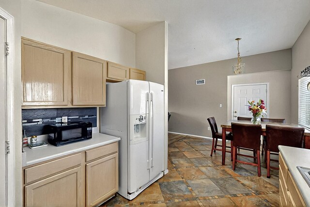 5401 Crown Ridge Rd NW, Albuquerque, NM 87114 - kitchen featuring white refrigerator with ice dispenser, black microwave, light brown cabinetry, and light countertops