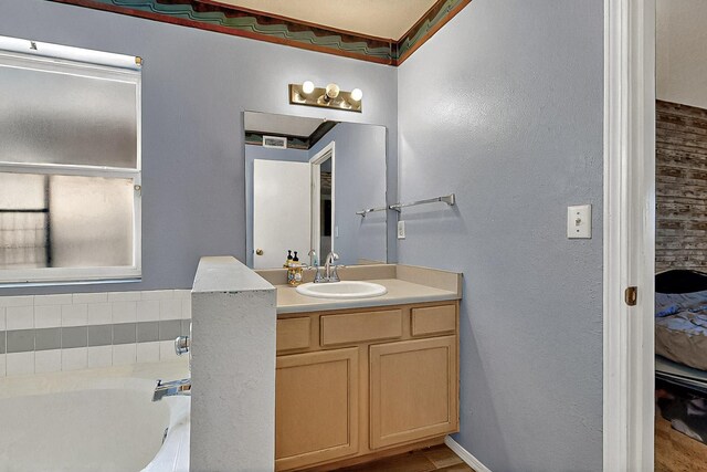 5401 Crown Ridge Rd NW, Albuquerque, NM 87114 - bathroom featuring a bath, vanity, wood finished floors, and a textured wall