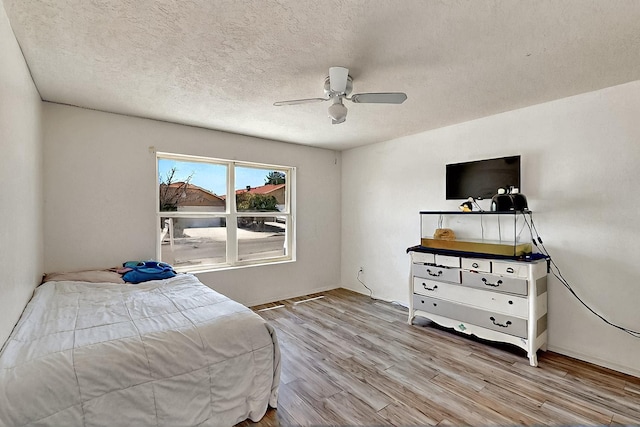 5401 Crown Ridge Rd NW, Albuquerque, NM 87114 - bedroom featuring wood finished floors, a ceiling fan, and a textured ceiling