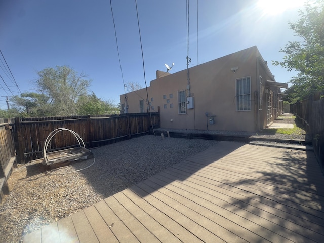 wooden deck with a fenced backyard