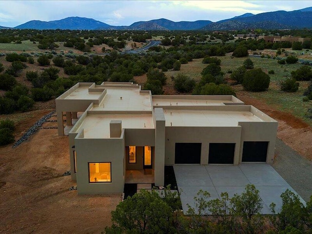 19 Anasazi Trl, Sandia Park, NM 87047 - view of front of home featuring a garage, a mountain view, stucco siding, and concrete driveway