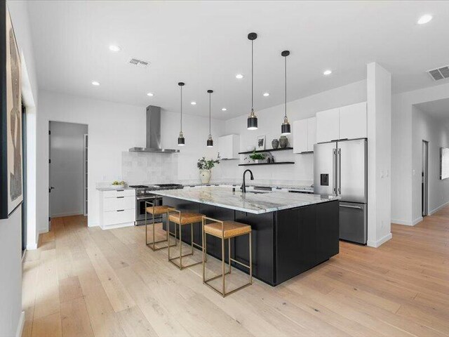 19 Anasazi Trl, Sandia Park, NM 87047 - kitchen with white cabinets, high quality appliances, open shelves, a sink, and wall chimney exhaust hood