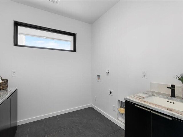 19 Anasazi Trl, Sandia Park, NM 87047 - laundry room featuring hookup for an electric dryer, cabinet space, a sink, baseboards, and hookup for a washing machine