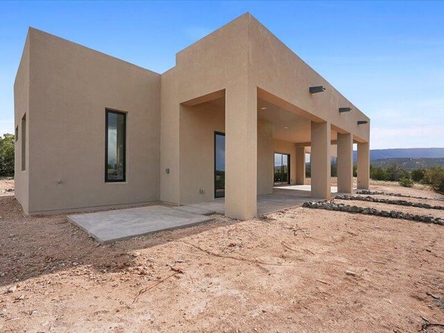 19 Anasazi Trl, Sandia Park, NM 87047 - rear view of property featuring stucco siding and a patio area