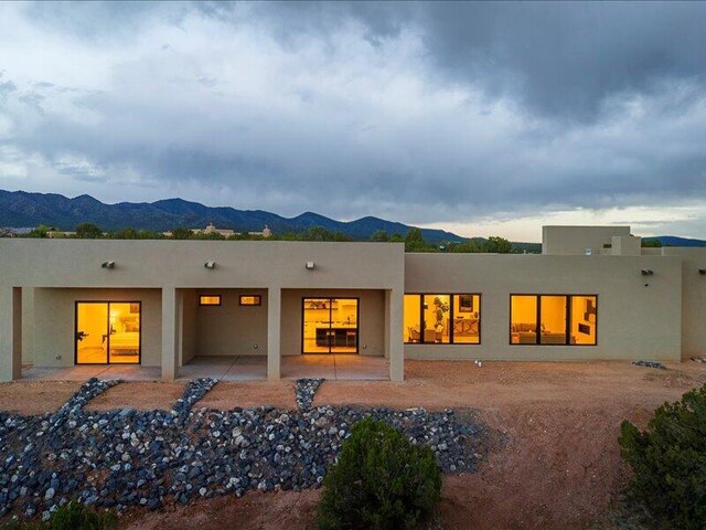 19 Anasazi Trl, Sandia Park, NM 87047 - rear view of house with a mountain view, stucco siding, and a patio