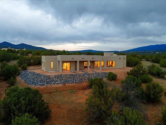 19 Anasazi Trl, Sandia Park, NM 87047 - back of house featuring a mountain view and stucco siding