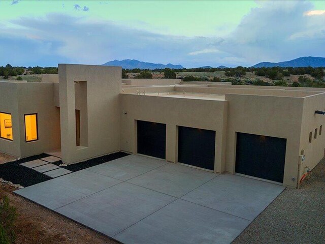 19 Anasazi Trl, Sandia Park, NM 87047 - view of side of home with driveway, a mountain view, and stucco siding