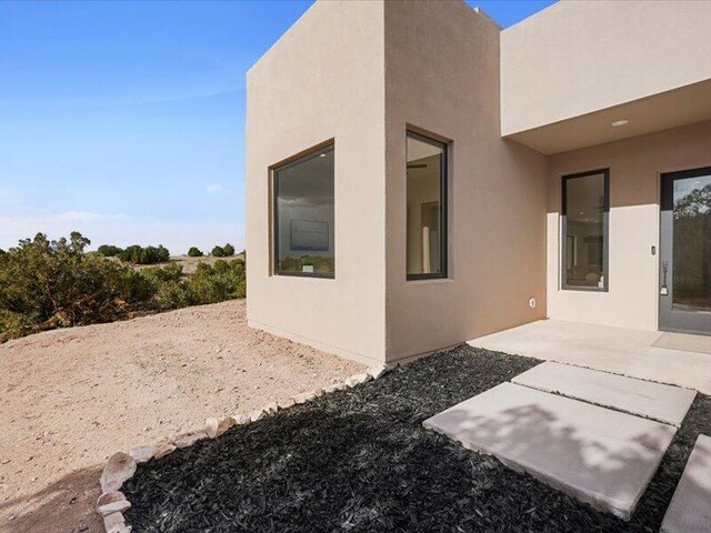 19 Anasazi Trl, Sandia Park, NM 87047 - rear view of house with a patio and stucco siding