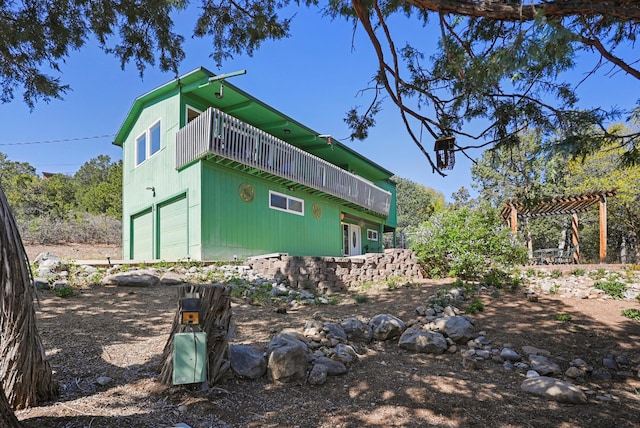 view of side of home featuring an attached garage and a pergola