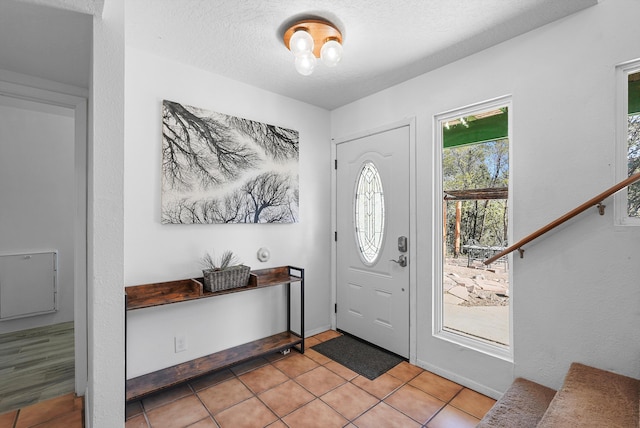 entrance foyer featuring a textured ceiling and light tile patterned flooring