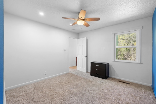 unfurnished bedroom featuring visible vents, baseboards, ceiling fan, a textured ceiling, and carpet flooring