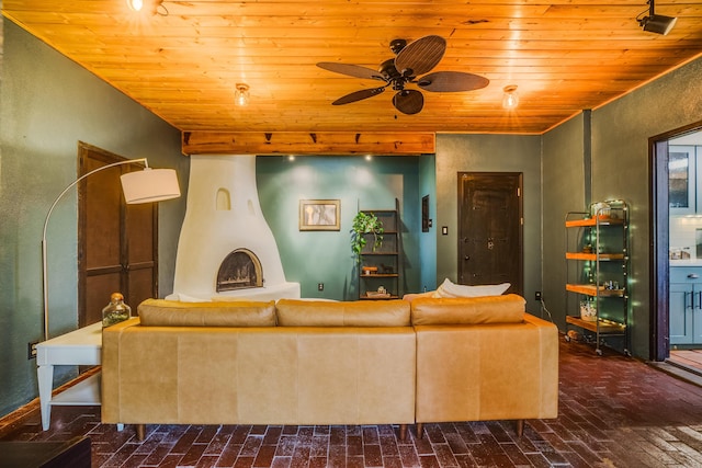 living area with a ceiling fan, wooden ceiling, and brick floor