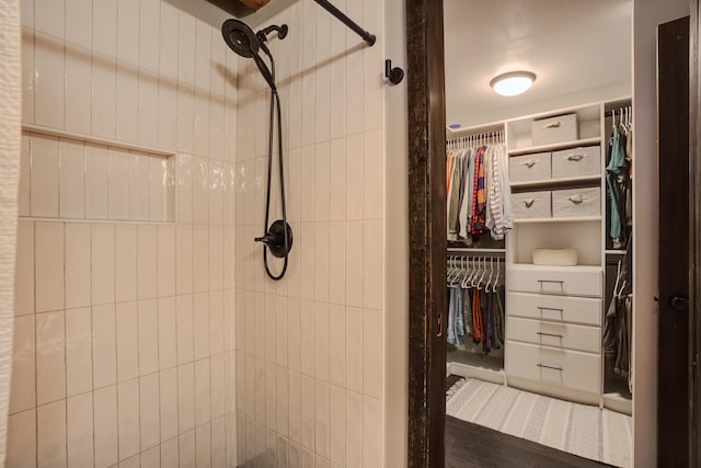 full bath with a tile shower and a spacious closet