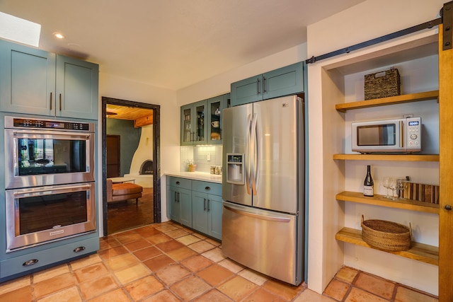 kitchen with green cabinetry, appliances with stainless steel finishes, open shelves, recessed lighting, and tasteful backsplash