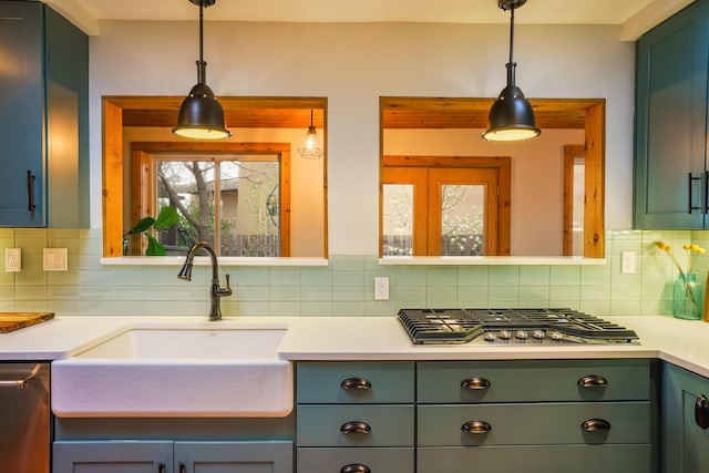 kitchen featuring a sink, decorative backsplash, stainless steel appliances, and green cabinetry