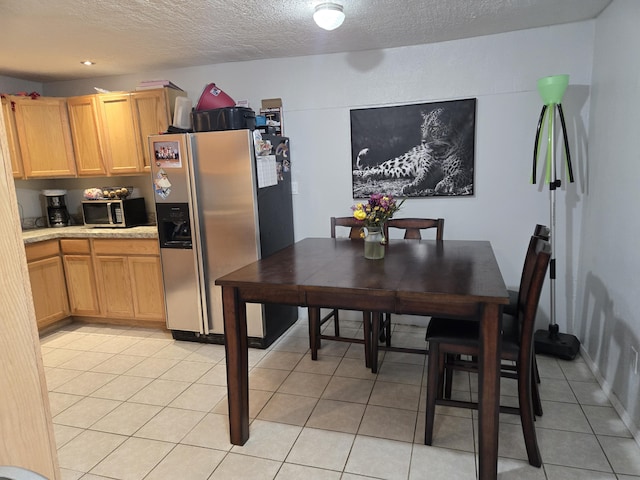 908 W Chavez Ave, Belen, NM 87002 - kitchen featuring light countertops, appliances with stainless steel finishes, light tile patterned flooring, and a textured ceiling