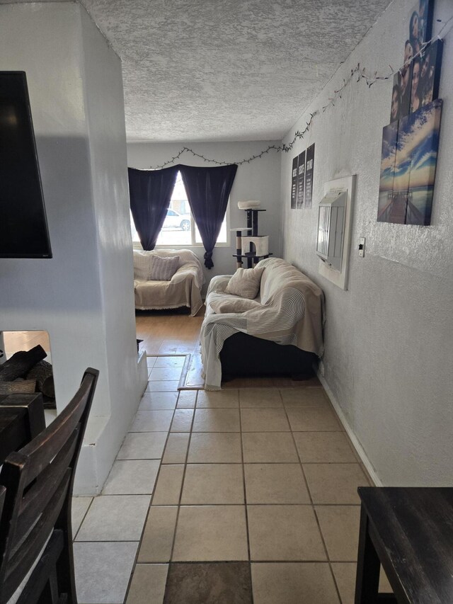 908 W Chavez Ave, Belen, NM 87002 - bedroom featuring tile patterned flooring, a textured wall, and a textured ceiling