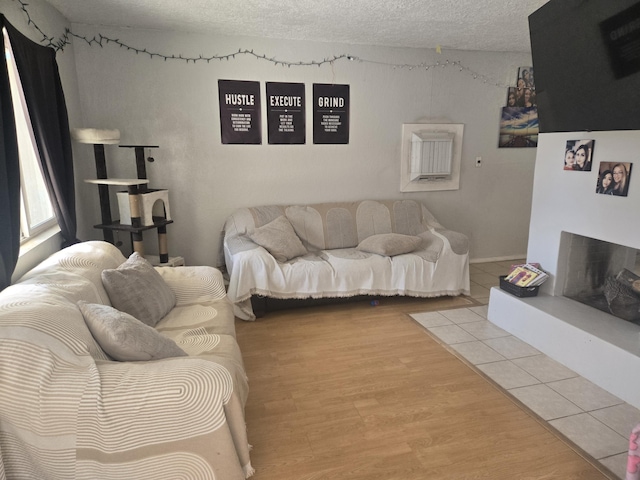 908 W Chavez Ave, Belen, NM 87002 - living area featuring a fireplace with raised hearth, a textured ceiling, and wood finished floors