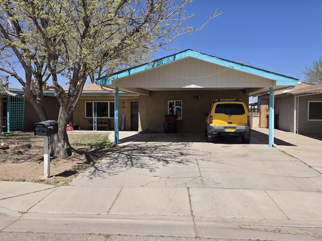 908 W Chavez Ave, Belen, NM 87002 - ranch-style house with stucco siding, an attached carport, and driveway