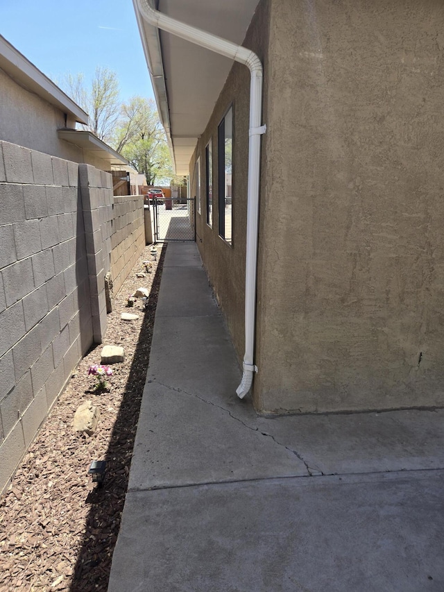 908 W Chavez Ave, Belen, NM 87002 - view of home's exterior with fence, a gate, and stucco siding