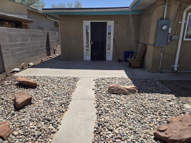 908 W Chavez Ave, Belen, NM 87002 - property entrance with fence, stucco siding, and a patio area