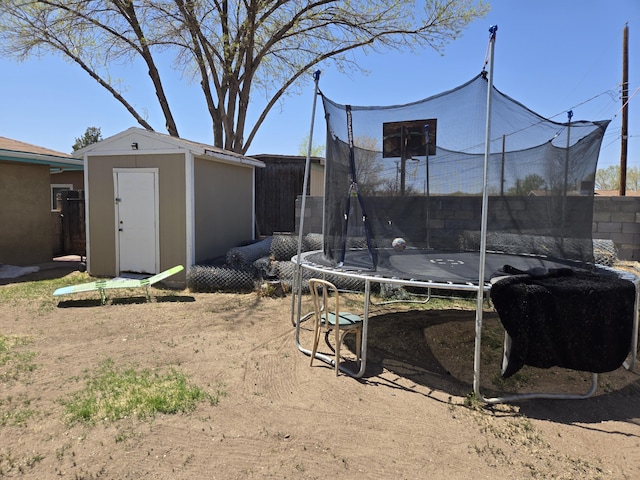 908 W Chavez Ave, Belen, NM 87002 - view of yard featuring fence, a trampoline, an outdoor structure, and a shed