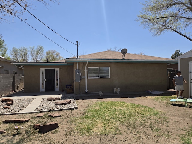 908 W Chavez Ave, Belen, NM 87002 - rear view of house with stucco siding and fence