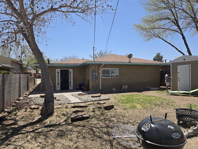 908 W Chavez Ave, Belen, NM 87002 - rear view of property featuring an outdoor structure, fence, a shed, and stucco siding