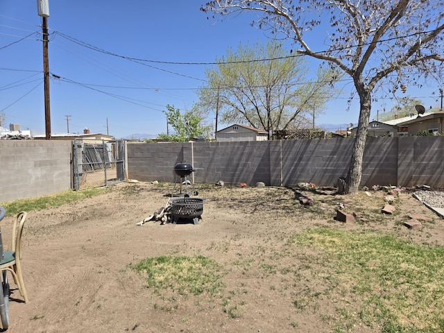 908 W Chavez Ave, Belen, NM 87002 - view of yard featuring a gate, a fenced backyard, and an outdoor fire pit
