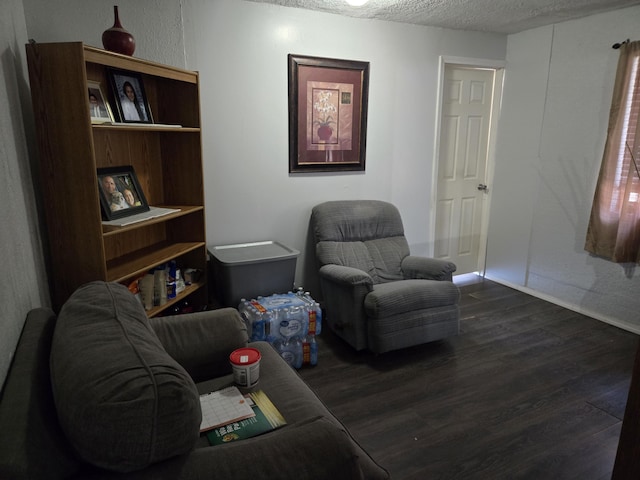 908 W Chavez Ave, Belen, NM 87002 - living area featuring baseboards, dark wood-style floors, and a textured ceiling