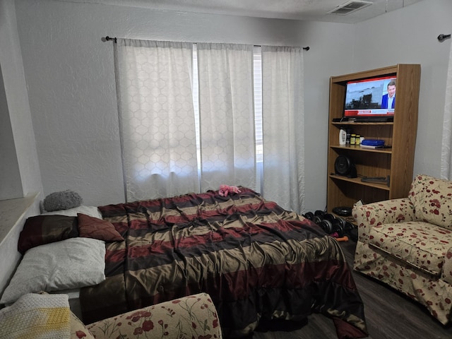 908 W Chavez Ave, Belen, NM 87002 - bedroom featuring visible vents, a textured wall, wood finished floors, and multiple windows