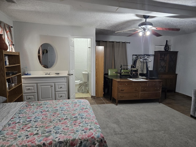 908 W Chavez Ave, Belen, NM 87002 - bedroom featuring carpet floors, a textured ceiling, a sink, and ensuite bathroom