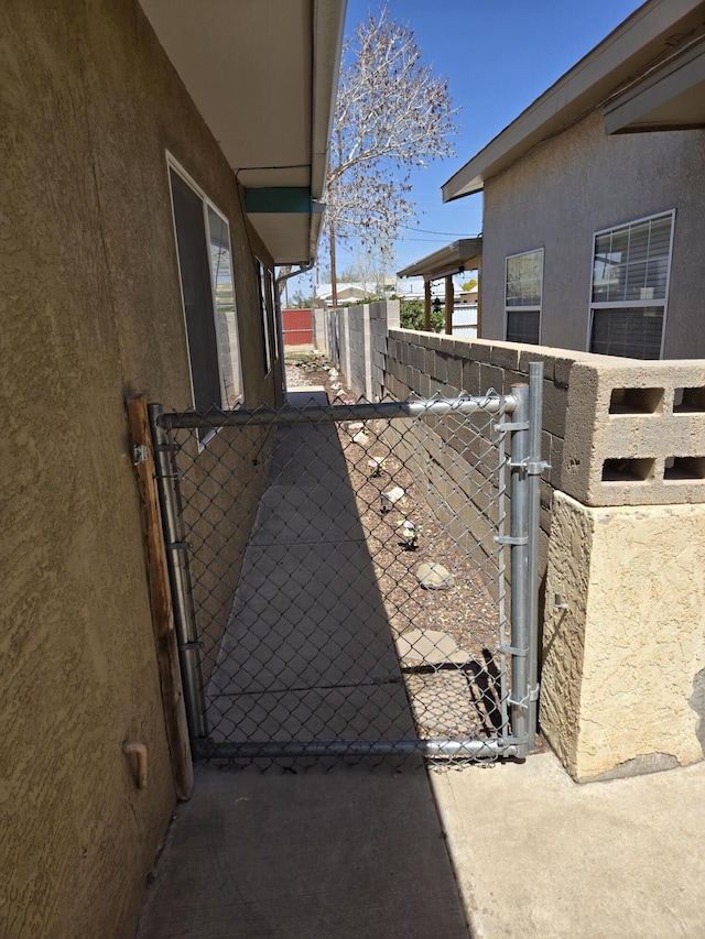 908 W Chavez Ave, Belen, NM 87002 - view of side of property featuring fence, a gate, and stucco siding