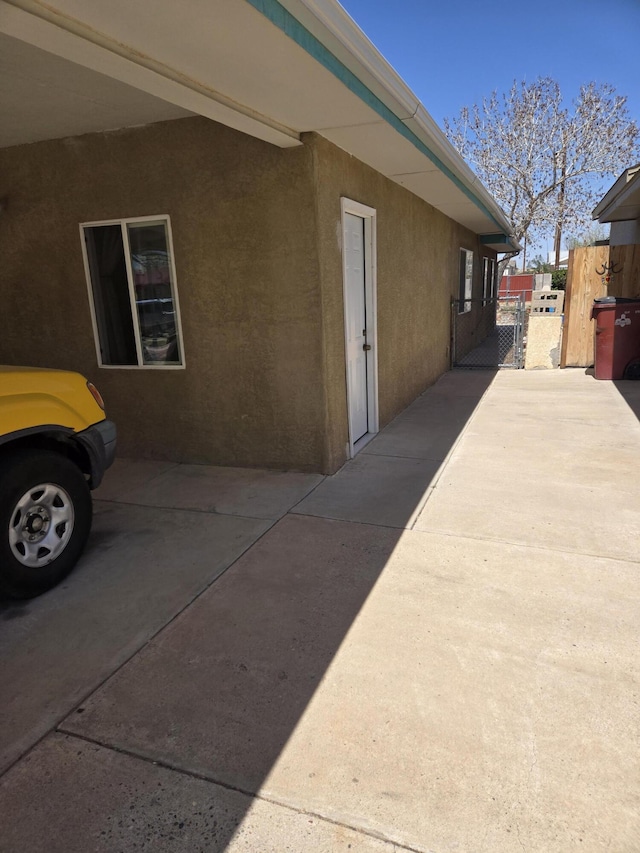 908 W Chavez Ave, Belen, NM 87002 - view of side of property with a gate, stucco siding, and fence