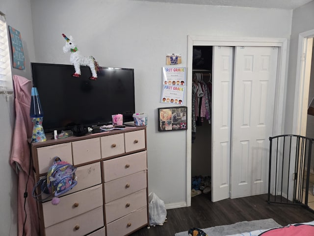 908 W Chavez Ave, Belen, NM 87002 - bedroom with baseboards, a closet, and dark wood-type flooring