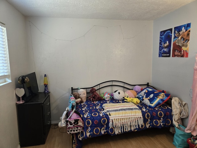 908 W Chavez Ave, Belen, NM 87002 - bedroom with a textured ceiling, wood finished floors, and multiple windows
