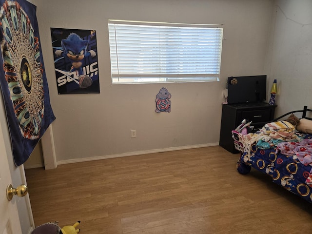 908 W Chavez Ave, Belen, NM 87002 - bedroom with baseboards and wood finished floors