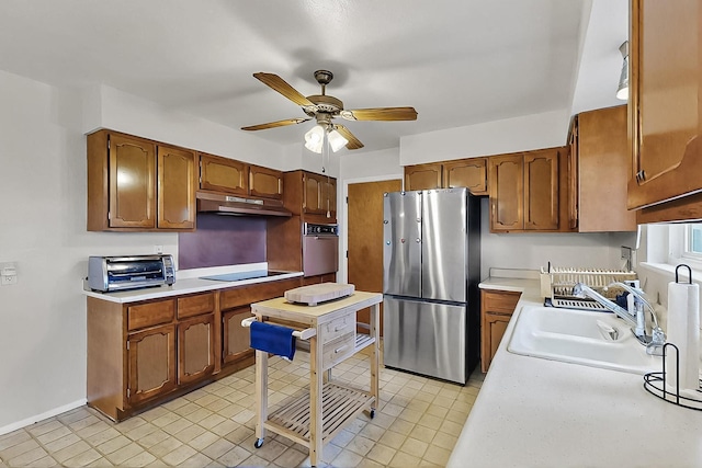 1513 Muriel St NE, Albuquerque, NM 87112 - kitchen with stainless steel appliances, under cabinet range hood, a ceiling fan, light countertops, and brown cabinets