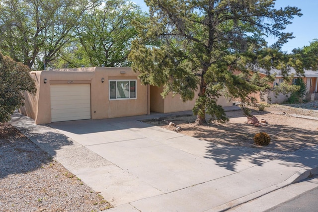 1513 Muriel St NE, Albuquerque, NM 87112 - view of front of home featuring an attached garage, stucco siding, and driveway
