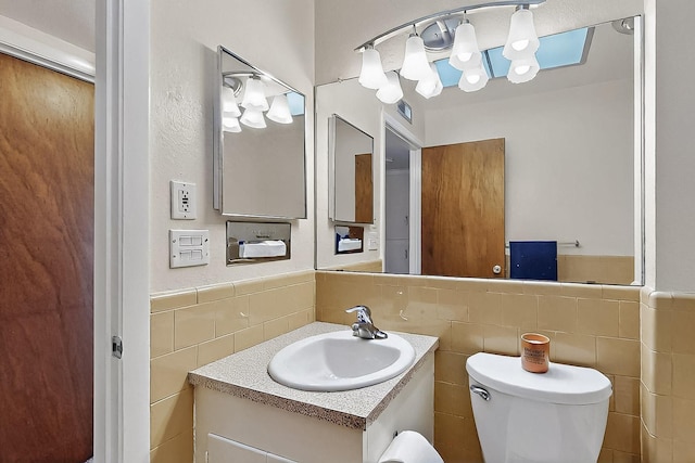 1513 Muriel St NE, Albuquerque, NM 87112 - bathroom featuring tile walls, vanity, and a wainscoted wall