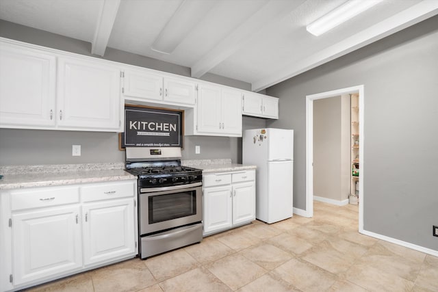 7225 Ticonderoga Rd NE, Albuquerque, NM 87109 - kitchen featuring stainless steel range with gas stovetop, freestanding refrigerator, white cabinetry, and beam ceiling