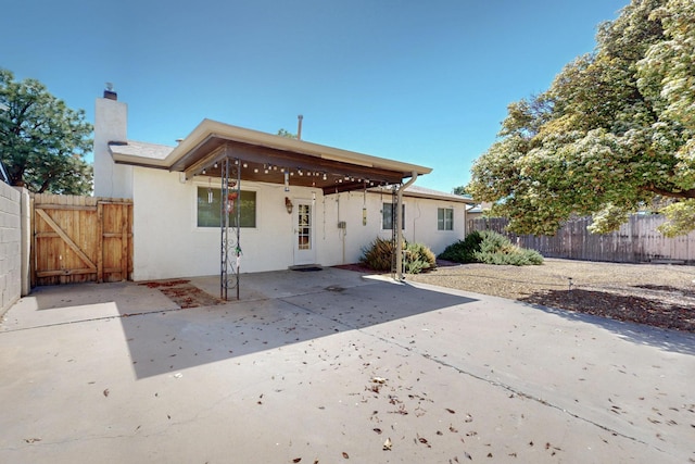6625 Barnhart St NE, Albuquerque, NM 87109 - rear view of property with fence, stucco siding, a gate, a chimney, and a patio